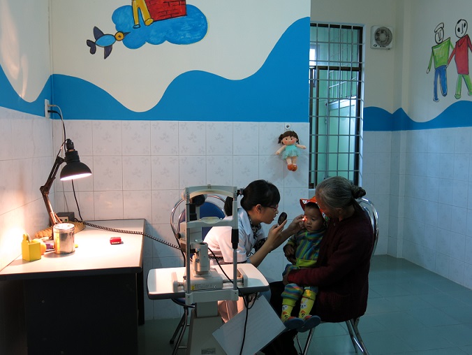 Cán bộ y tế khám mắt cho trẻ tại Bệnh viện Mắt Bình Định