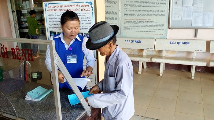 Cán bộ Tổ công tác xã hội đang tiếp đón, hướng dẫn thủ tục cho người dân đến khám, chữa bệnh tại Trung tâm Y tế huyện Hoài Nhơn.
