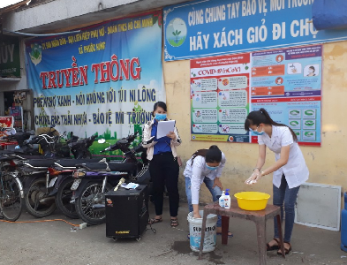 Tăng cường công tác truyền thông, hướng dẫn cho người dân rửa tay bằng xà phòng và dung dịch sát khuẩn tại các chợ ở xã Phước Hưng huyện Tuy Phước. (Ảnh Thùy Vy)