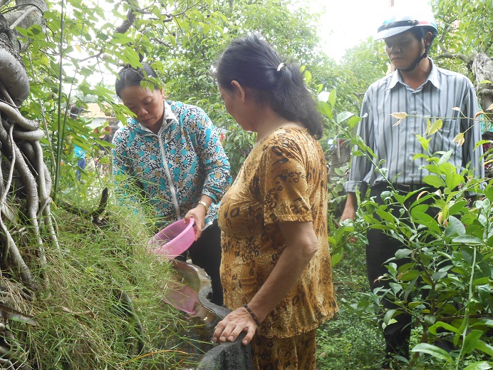 Cán bộ y tế hướng dẫn người dân thực hiện các biện pháp diệt muỗi, diệt bọ gậy /loăng quăng để phòng bệnh sốt xuất huyết. (Ảnh Thùy Vy)