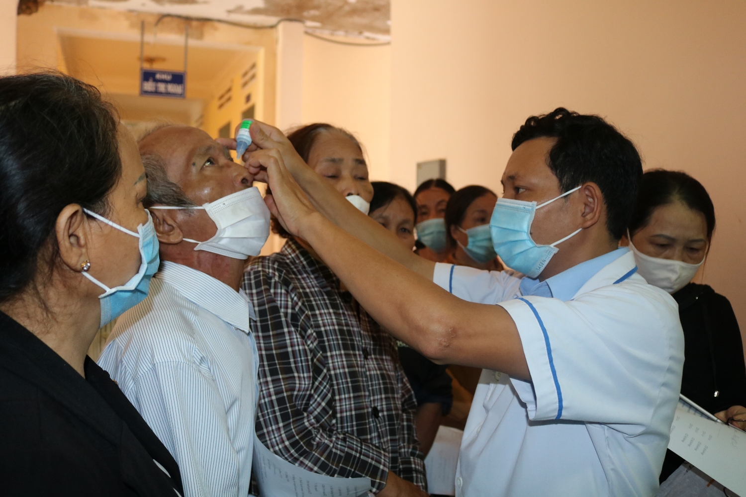 Nhân viên y tế nhở thuốc cho người bệnh ĐTĐ để chụp phát hiện bệnh VMĐTĐ.(ảnh Thu Hiền)