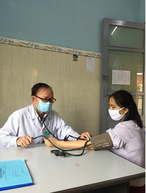 BSCKI. Võ Sanh Tùng - Trưởng Trạm y tế Phường Bình Định đang đo huyết áp cho người dân (Ảnh Tuyết Nga)