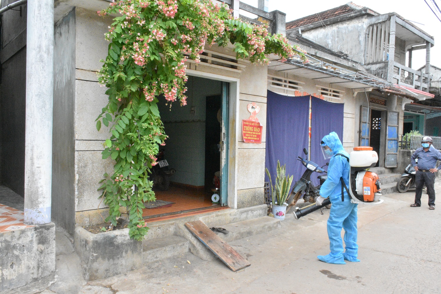  Nhân viên y tế phun thuốc khử trùng cho hộ gia đình có người trong mẫu gộp dương tính với Covid-19